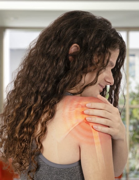 young woman clenching shoulder highlighted red to represent pain from shoulder cuff injury