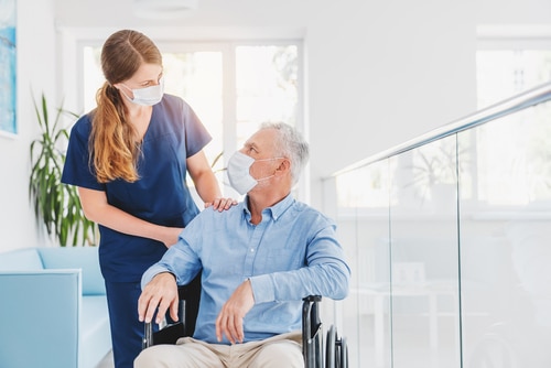 Young woman nurse explaining information to man patient in wheelchair