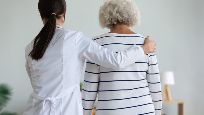 Caretaker walking with elderly Parkinson's patient in Show Low, AZ
