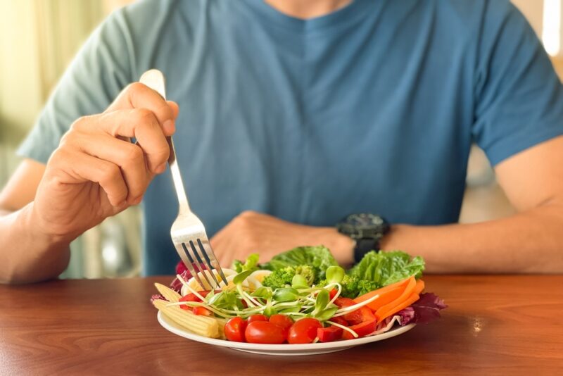 Close up of man eating salad to control diabetes in Show Low, AZ
