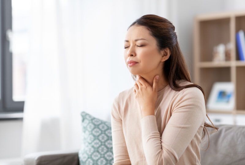 Woman holding her neck due to sore throat in Show Low, AZ