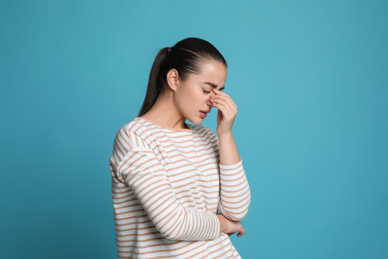 Woman holding her head with a headache, needing neurology care in Show Low, AZ